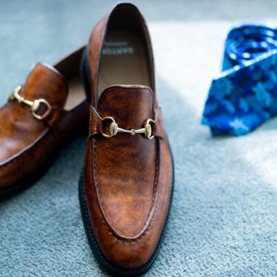 Classy brown shoes and tie placed on floor