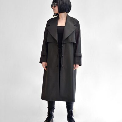 Young stylish female in black wear and sunglasses looking away on white background